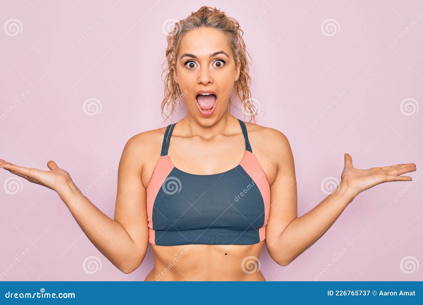 молодая красавица блондинка, занимающаяся спортом в спортивной одежде, в  порно-боязни на розовом фоне, празднующая безумство и пор Стоковое  Изображение - изображение насчитывающей тренировка, пинк: 226765737