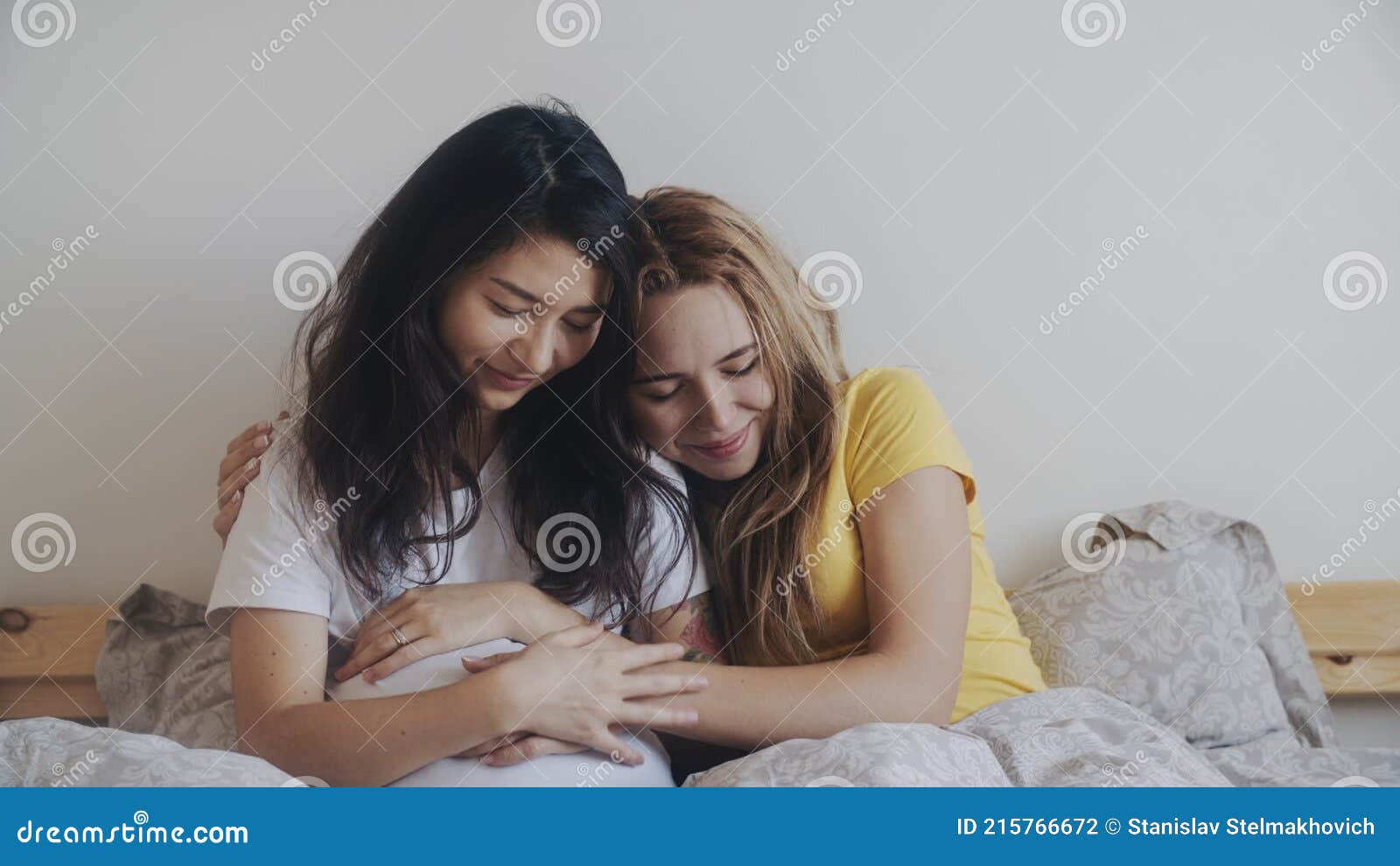 молодая лесбийская пара ждет ребенка. счастье материнства блондинка гладитживот своей беременной азии видеоматериал - Видео насчитывающейматеринство, супоросо: 215766672