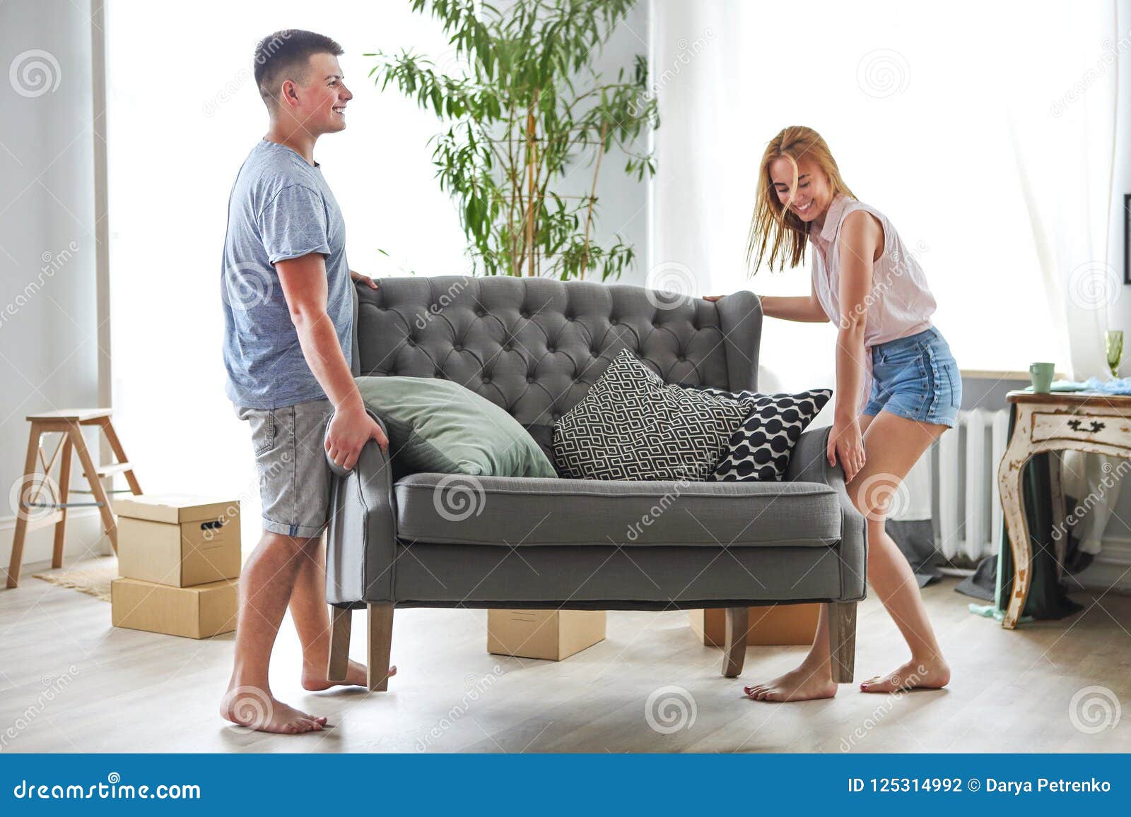 Отблагодарил соседку. Девушка двигает диван. Девушка двигает мебель. Порядок на диване. Девушка с трудом двигает диван.