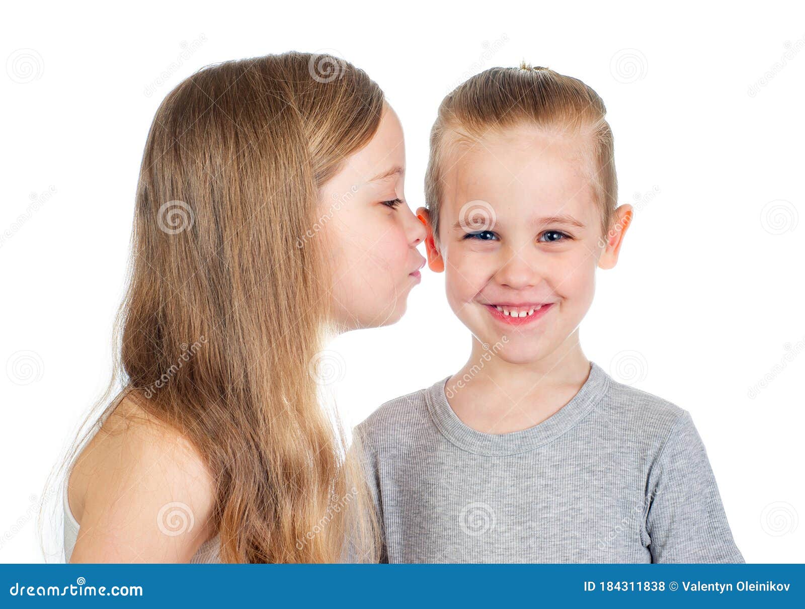 Boys kiss girls. Мальчик целует девочку. Мальчик целует девочку на белом фоне. Девочка целует мальчика в щеку стоковое изображение. Мальчик и девочка улыбаются.