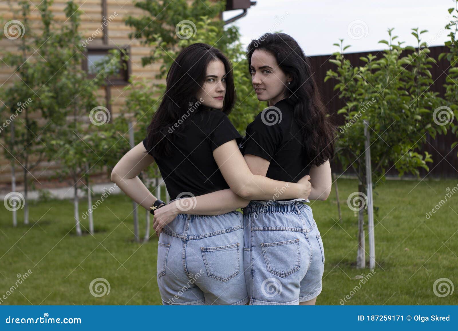 2 Молодых женщин брюнетки в черный обнять трусы футболки и джинсовой ткани.  Сестры Girlfriendsfamily и концепция дружбы Стоковое Изображение -  изображение насчитывающей сестра, объятие: 187259171
