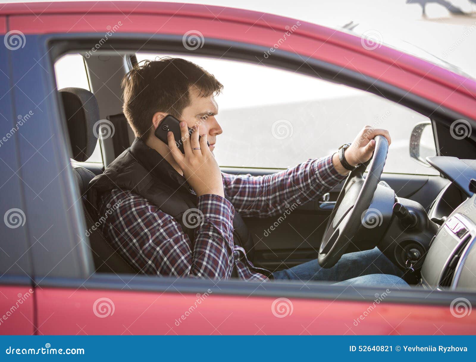 Водитель за рулем. Двое людей в машине. Разговор за рулем. Водитель с телефоном. Мужчина разговаривает по телефону за рулем.