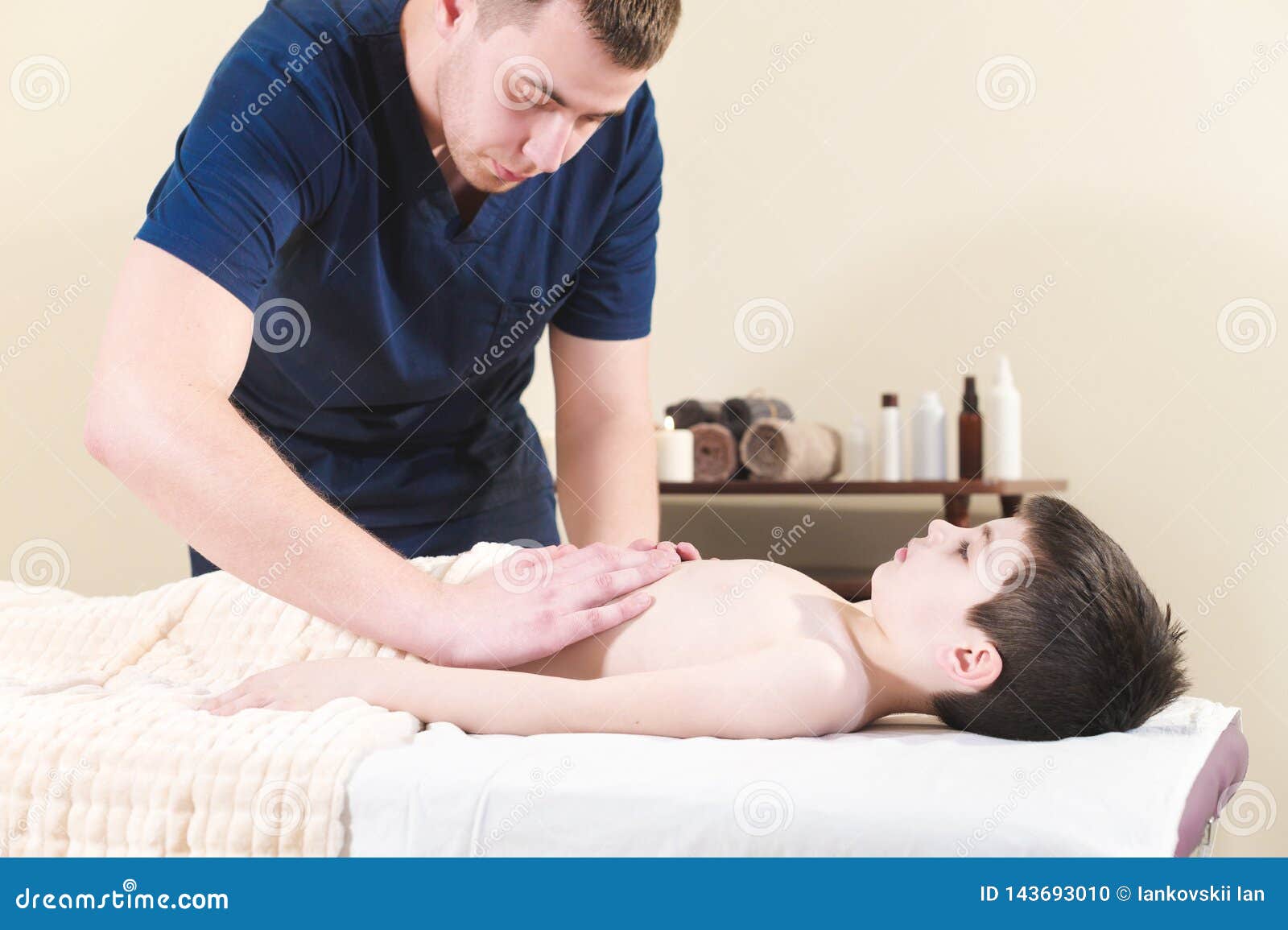 Little massage. Кровать с массажем. Мальчик на массаже стоковое. Child getting massage.