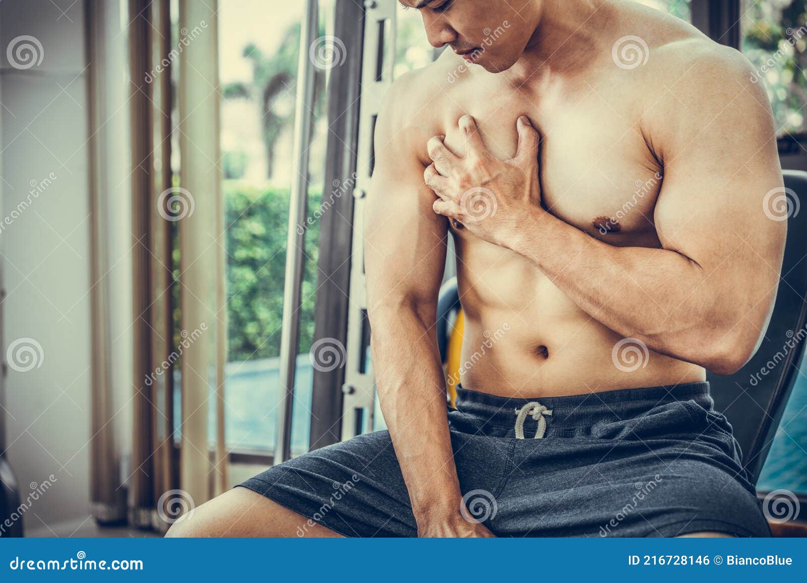 мускулистый мужчина трогает грудь в фитнес-центре. Стоковое Фото - изображение насчитывающей модель, мышца: 216728146