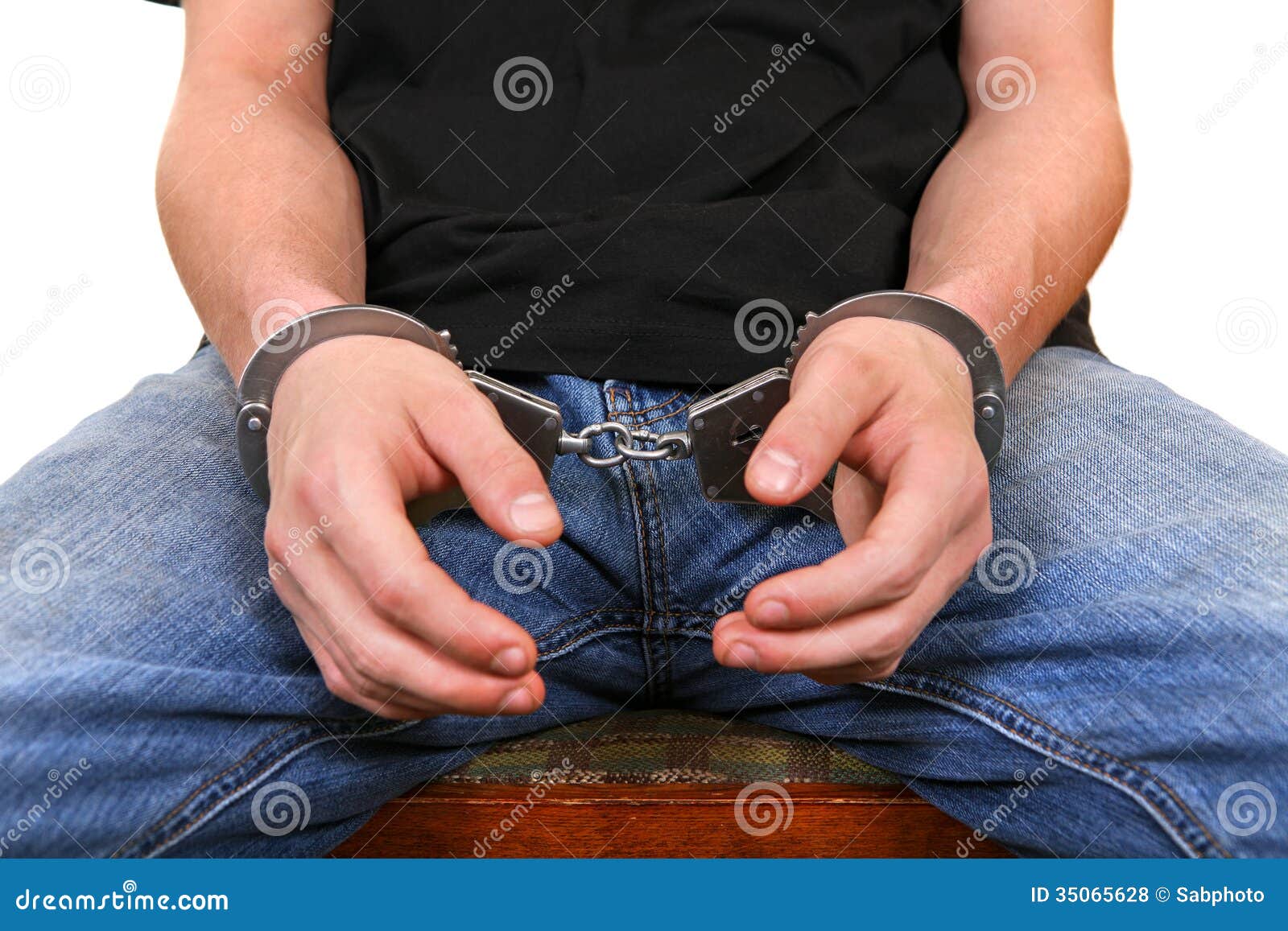 Парень надевает наручники. Наручники на джинсах. На мужика надели наручники. Наручники крупным планом. Мужчина в наручниках и в джинсах.