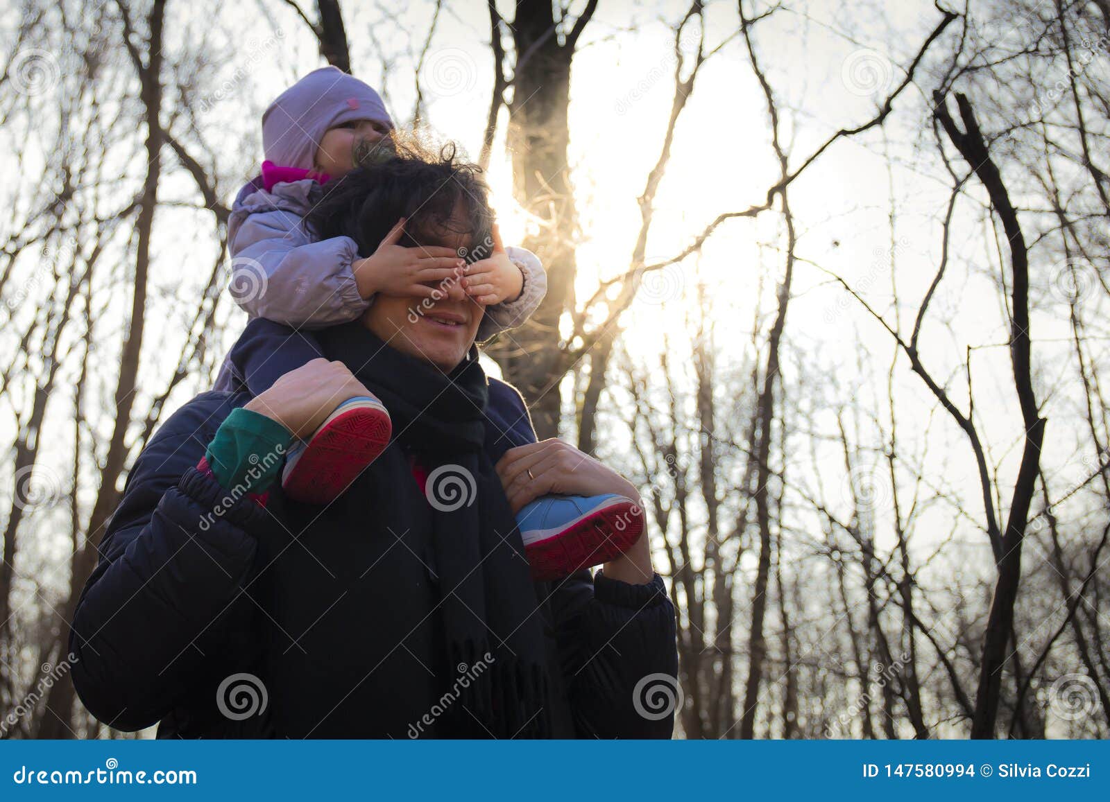 мальчик несет своего отца. мужчина с ребенком на руках. ребенок плачет. сын на плечах. мальчик несет своего отца.