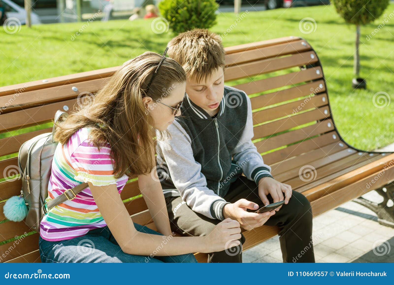 Сами играет читать. Мальчик играет а девочка читает. Девочки подростки играются у дома. Подростки парень и девушка играются между собой на улице. Девочка читает книгу на скамейке в парке.