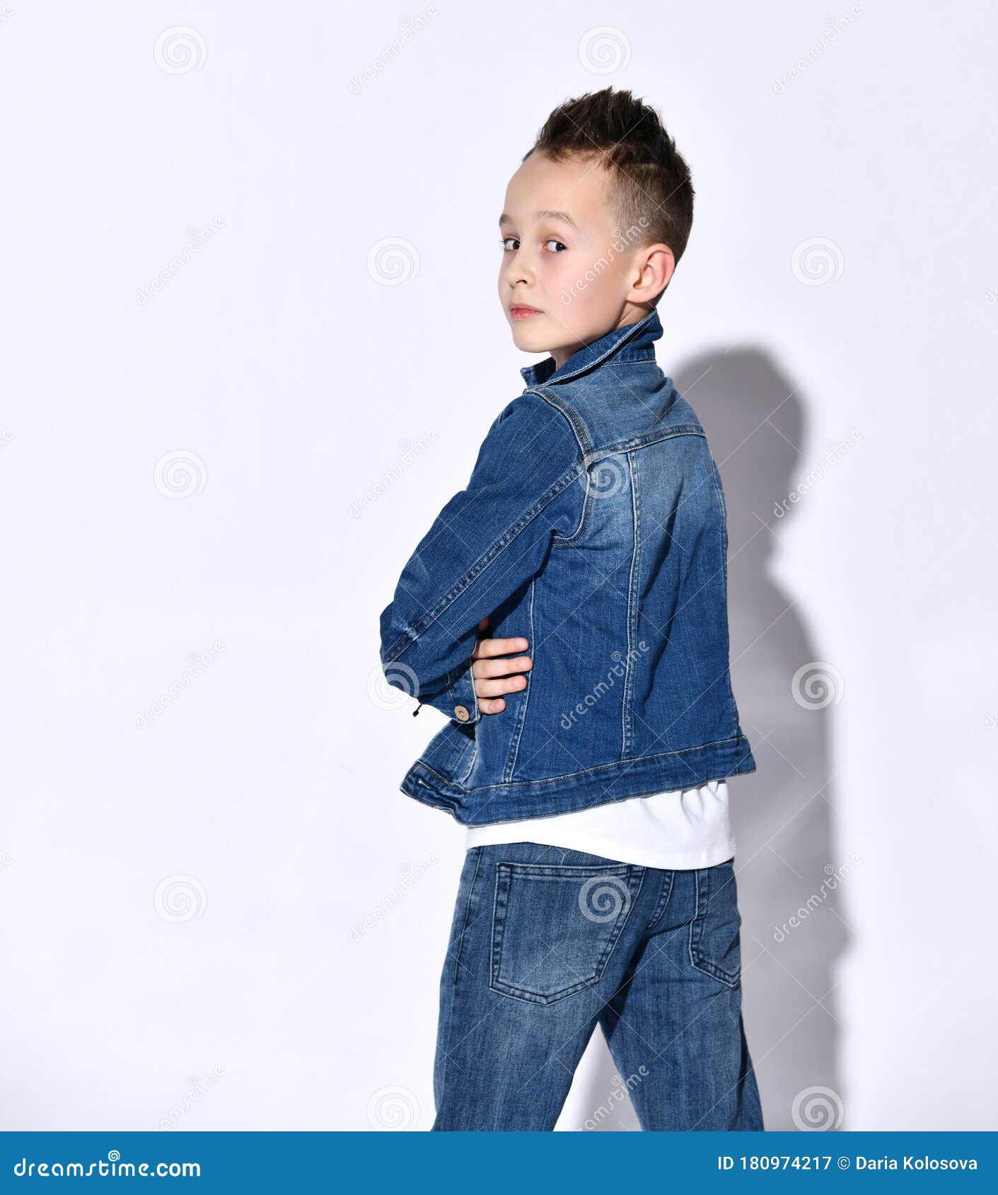 Подросток в куртке джинсовой ткани синие джинсы футболки. Он готовя егообратно в палату оглядываясь на белом изолированную предст СтоковоеИзображение - изображение насчитывающей битник, конец: 180974217