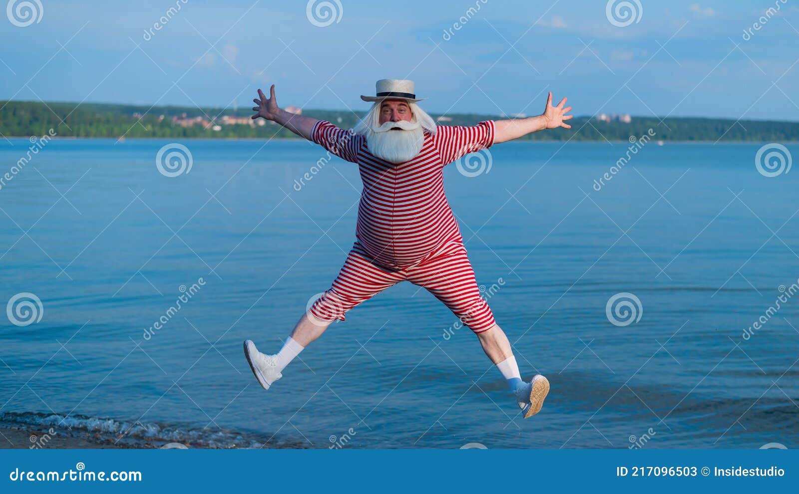 пожилой мужчина в полосатом купальнике и лодочнике бегает и прыгает по  пляжу. веселый седой старик Стоковое Изображение - изображение  насчитывающей релаксация, подныривание: 217096503