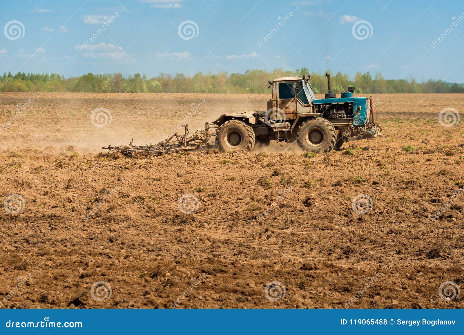 Трактор пашет поле