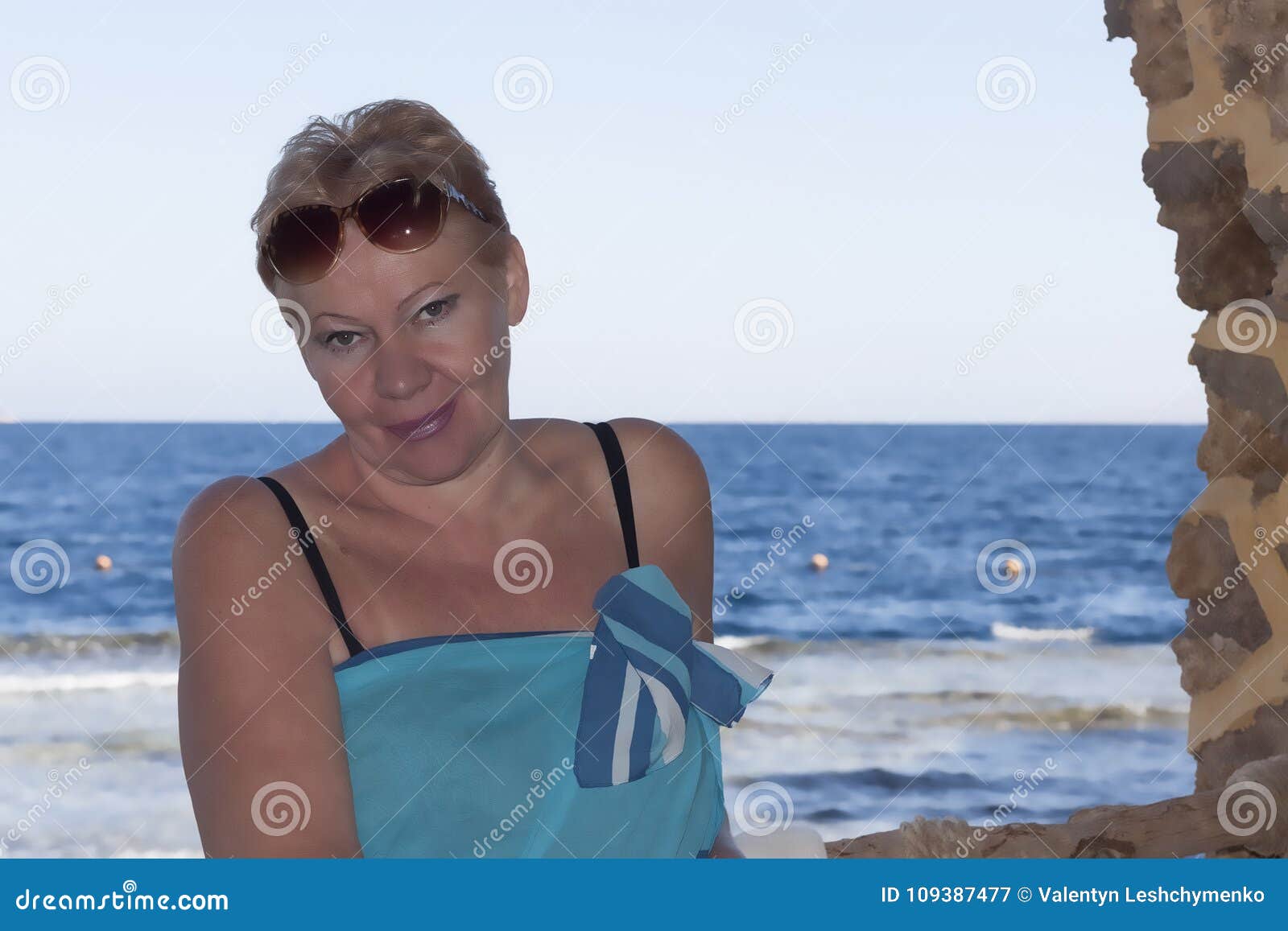 Зрелая женщина позирует на пляже