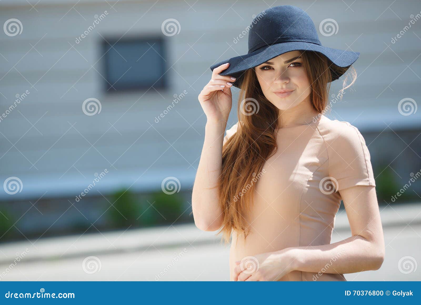 A Beautiful Brunette Woman In A Beige Dress In A Closeup