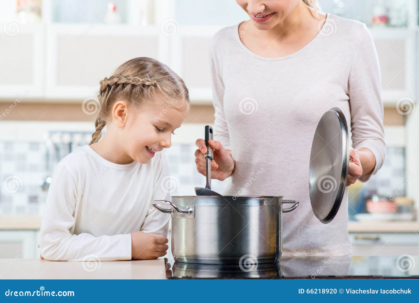 мама и дочь готовят. мам есть суп. еда для детей. мам есть суп. готовка на кухне.