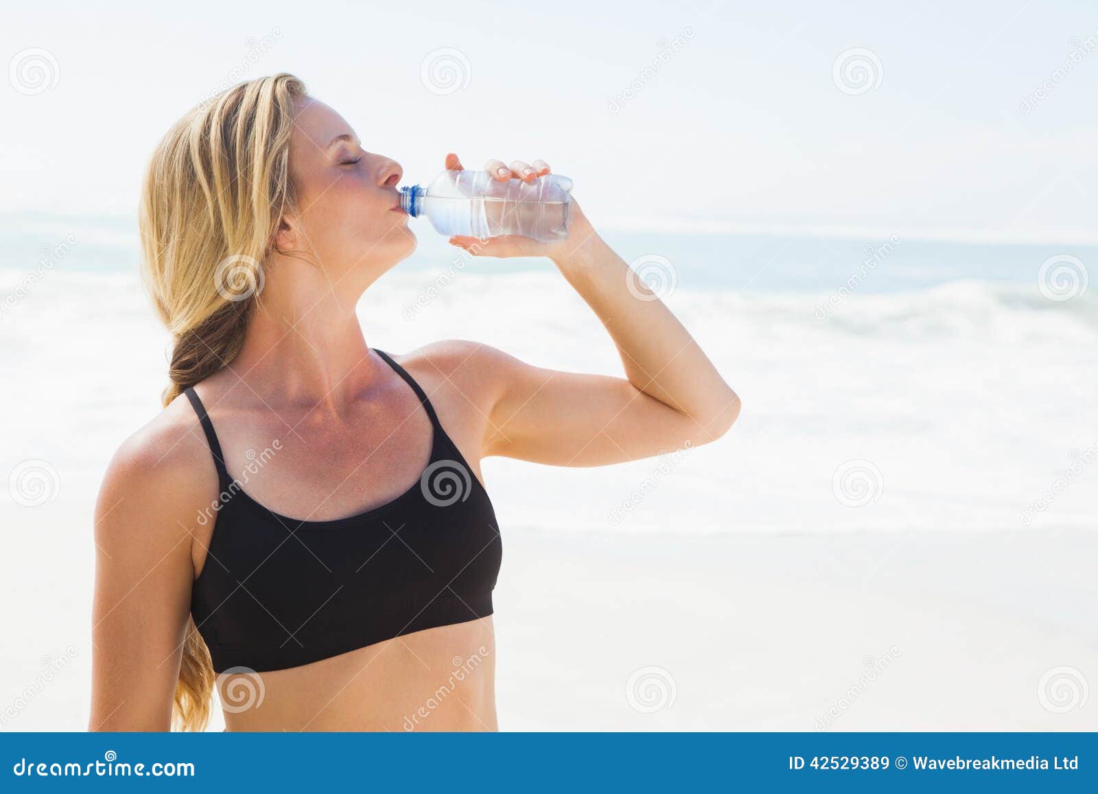 Blonde drink. Пить воду на пляже. Девушка пьет воду на пляже. Спортивная девушка в очках пьет воду. Beautiful woman drinking Drink on the Beach.