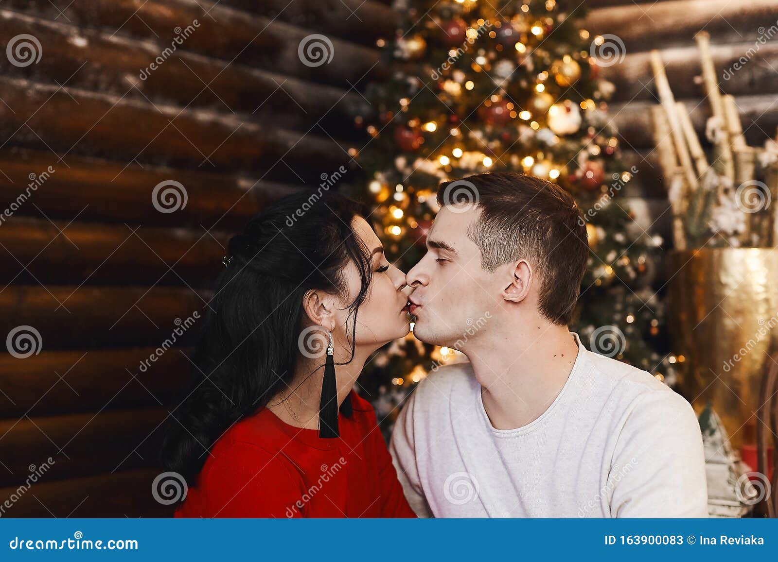 Прекрасная мол��дая пара, парень в свитере и девушка в сексуальном платьецелуются в рождественской интерьере Молодые Стоковое Изображение -изображение насчитывающей влюбленность, женщина: 163900083