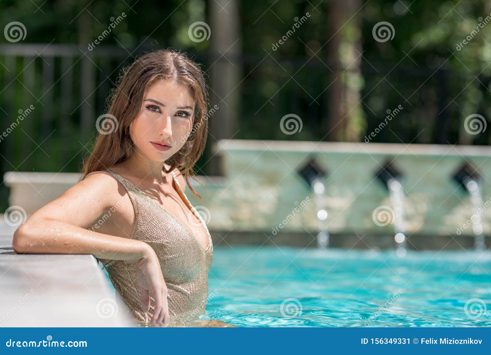 Зрелая дама с большой грудью позирует у бассейна