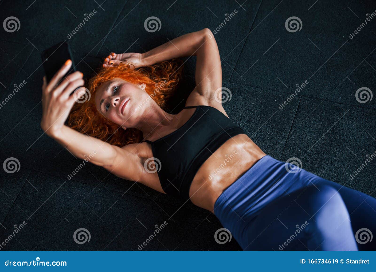 Принятие Selfie с телефоном В джинсовом девушка рыжий есть день фитнеса в  тренажерном зале в дневное время Мускулистый тип тела Стоковое Изображение  - изображение насчитывающей тонкий, комната: 166734619