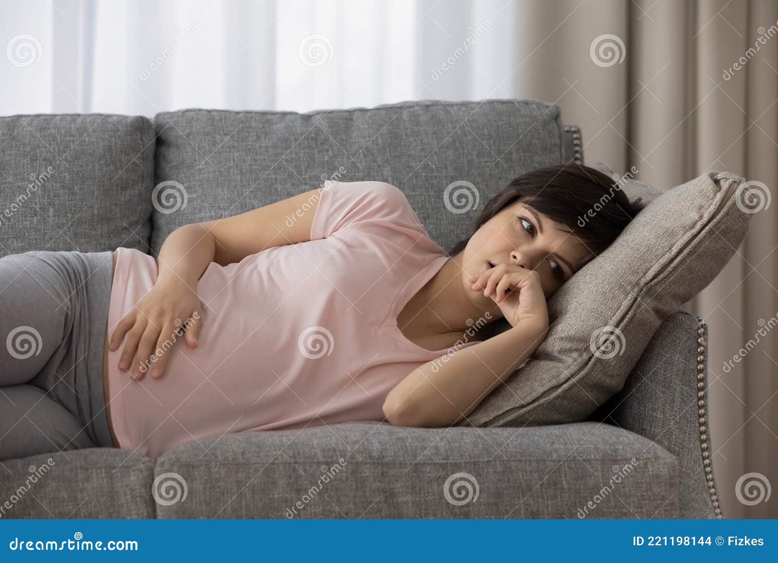 расстроенная задумчивая беременная женщина лежит на диване однатрогательный живот Стоковое Фото - изображение насчитывающей концепция,девушка: 221198144