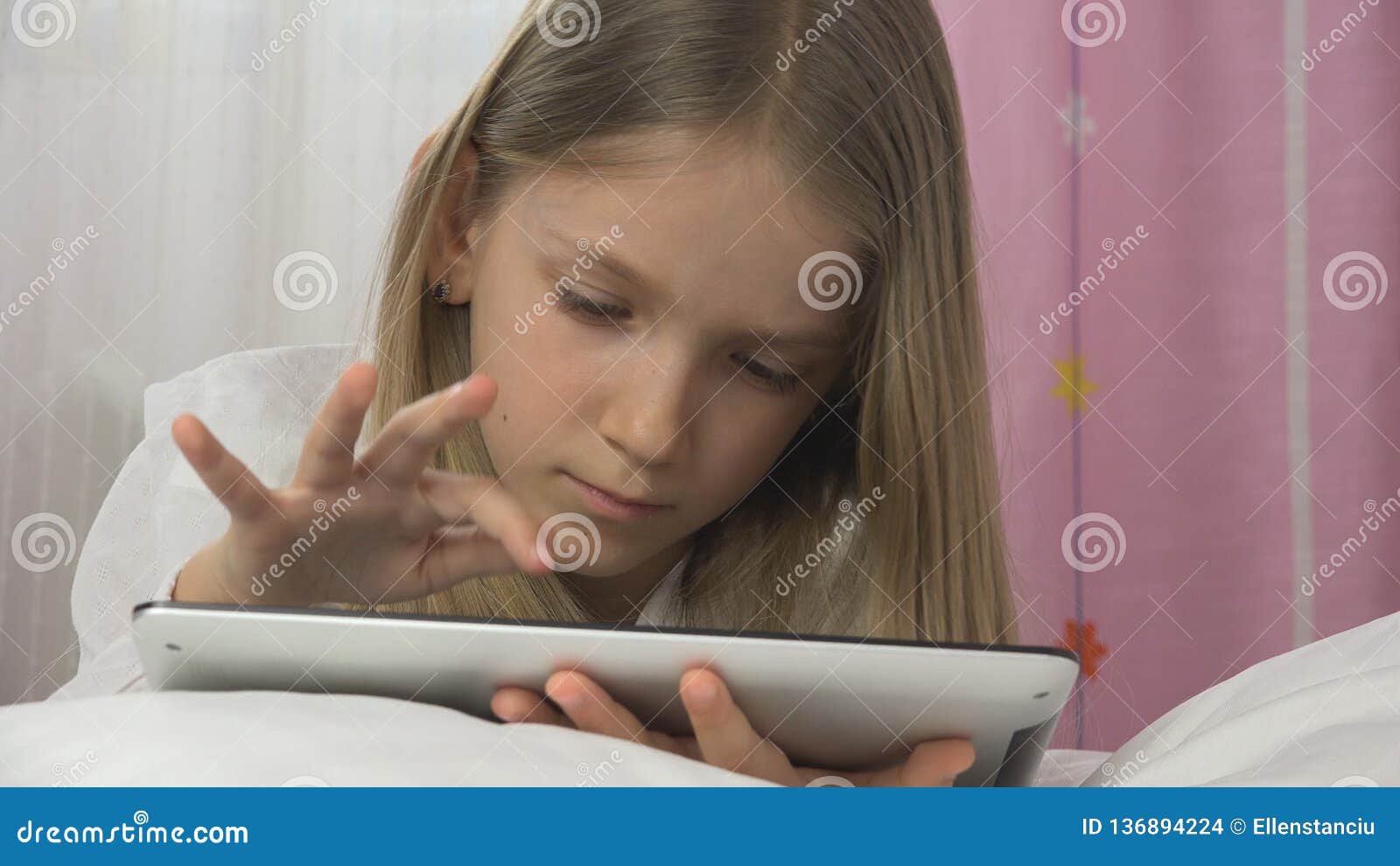 Русский домашний юные разговор. Девочка играет в планшет на кровате. Играть в планшет в кровати. Девочка с планшетом на коленках фото. Девочка играет в планшет в комнате домашнее.
