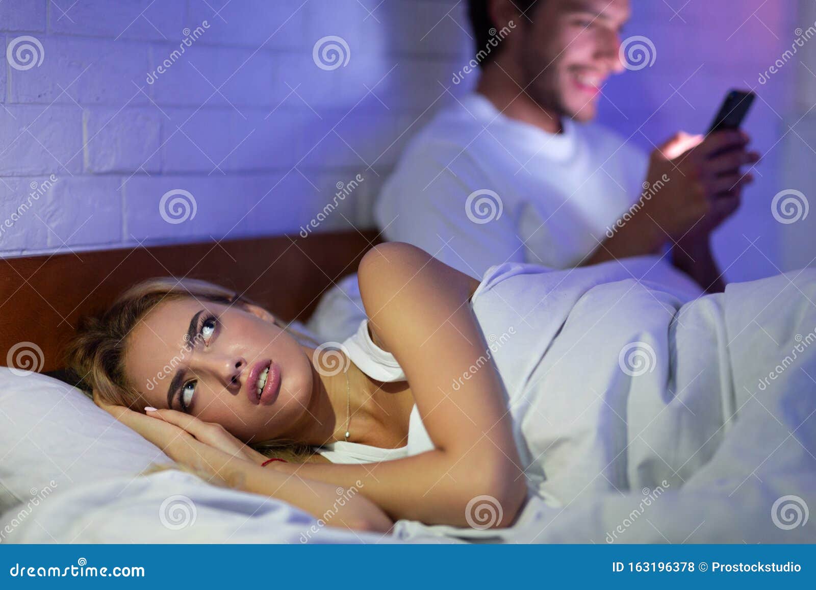 Русское видео с мужем по телефону. Девушка с телефоном в кровати. Девушка лежит с телефоном. Женщина смотрит в телефон мужа.