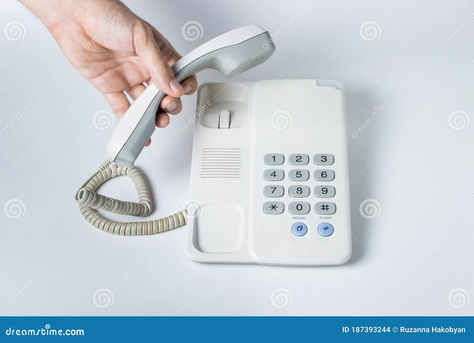 Рука поднимает трубку телефона Landline. Белый телефон наземной линии связи  с помощью кнопок. Стоковое Фото - изображение насчитывающей контакт,  черный: 187393244
