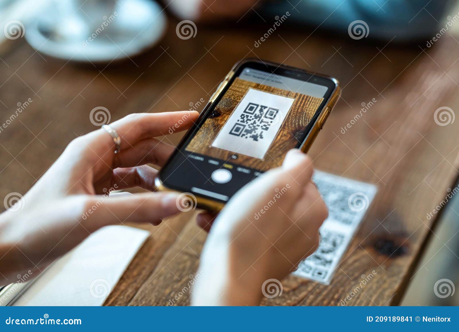 Руки молодой женщины, используя смартфон для того, чтобы просмотреть код Qr  для того, чтобы выбрать в меню блюда в ресторане Стоковое Изображение -  изображение насчитывающей покупка, код: 209189841