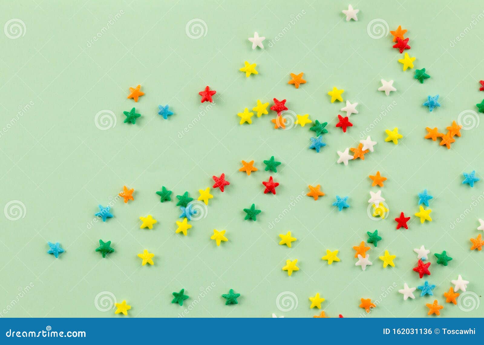 Спринкл-фон с ярко-красочными звездами, разбросанными на бледно-зеленый фон,  с пространством для текста - фото сверху Стоковое Фото - изображение  насчитывающей цветасто, торжество: 162031136