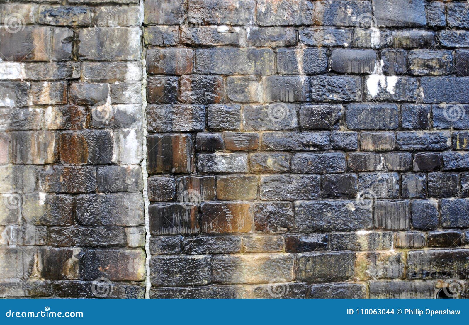 Старая скачками влажная каменная стена с влажными метками и водой исчерчивает в тенях черноты и коричневого цвета Стоковое Фото - изображение насчитывающей тени, черный: 110063044