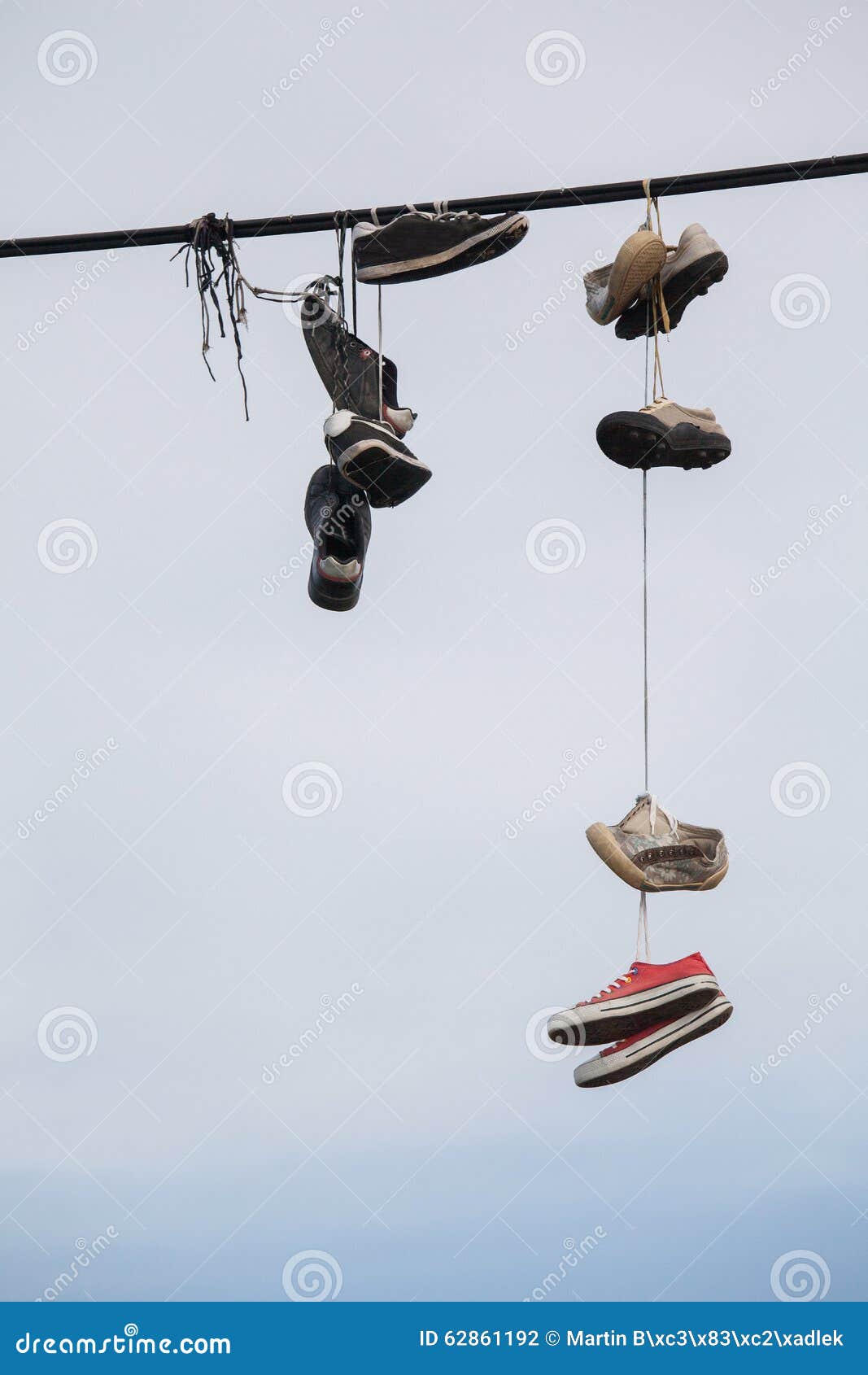 Почему висят кроссовки. Старый башмак на проводах. Тапочки висят на проводах. Обувь висит на электропроводах.