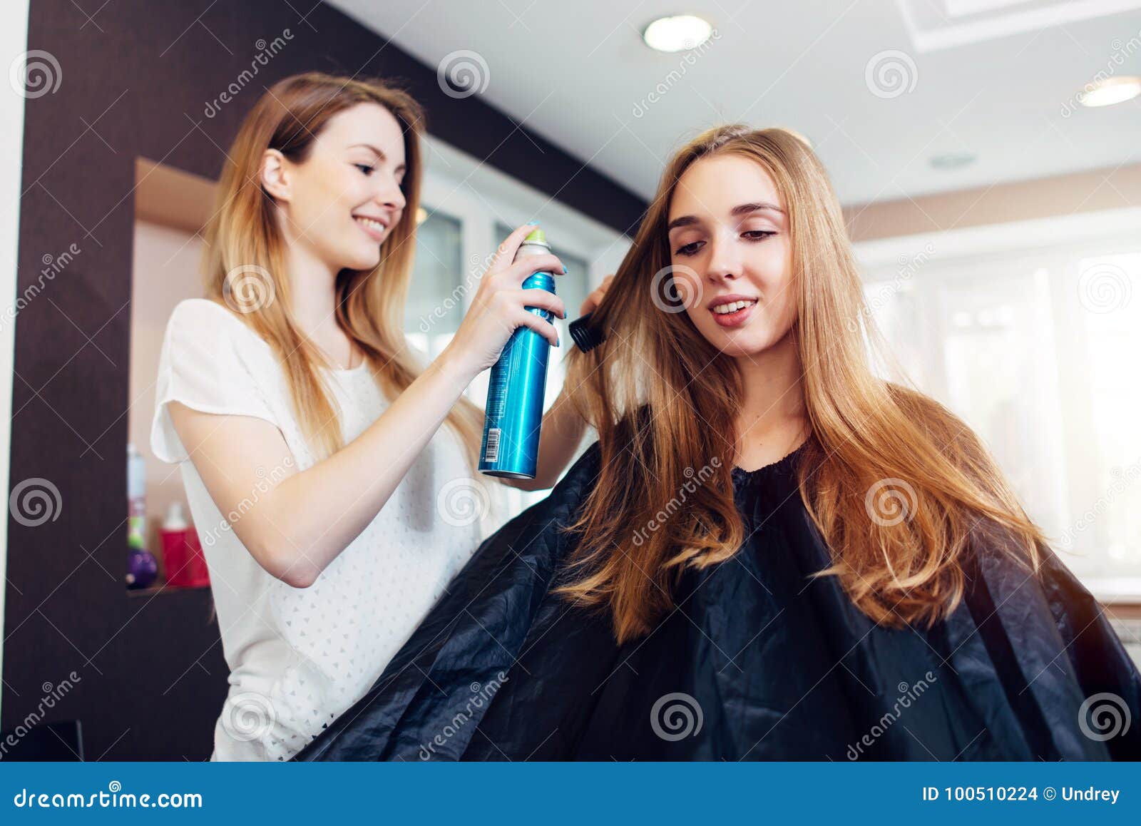Стиль причёсок отладки парикмахера усмехаясь женского клиента с лаком для волос в салоне красоты парикмахерских услуг Стоковое Фото - изображение насчитывающей внимательность, длиной: 100510224