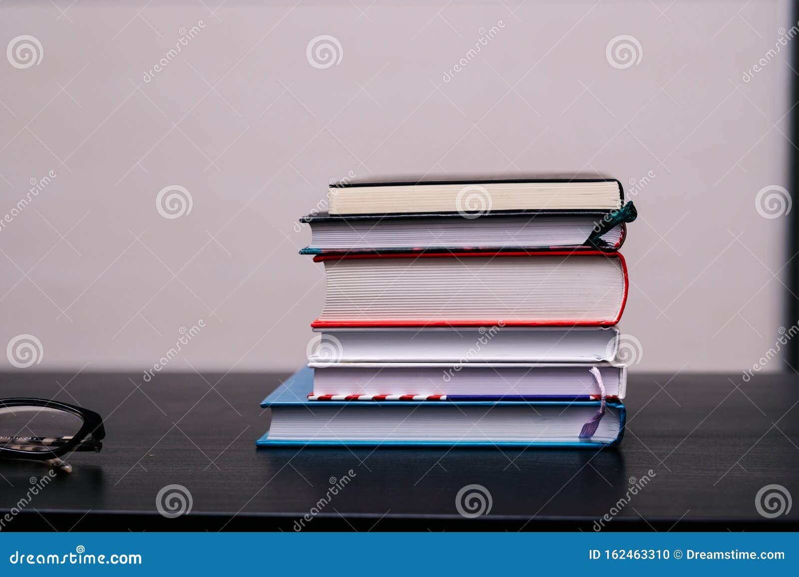 Стопка книг на столе стоковое фото. изображение насчитывающей ведущего -  162463310