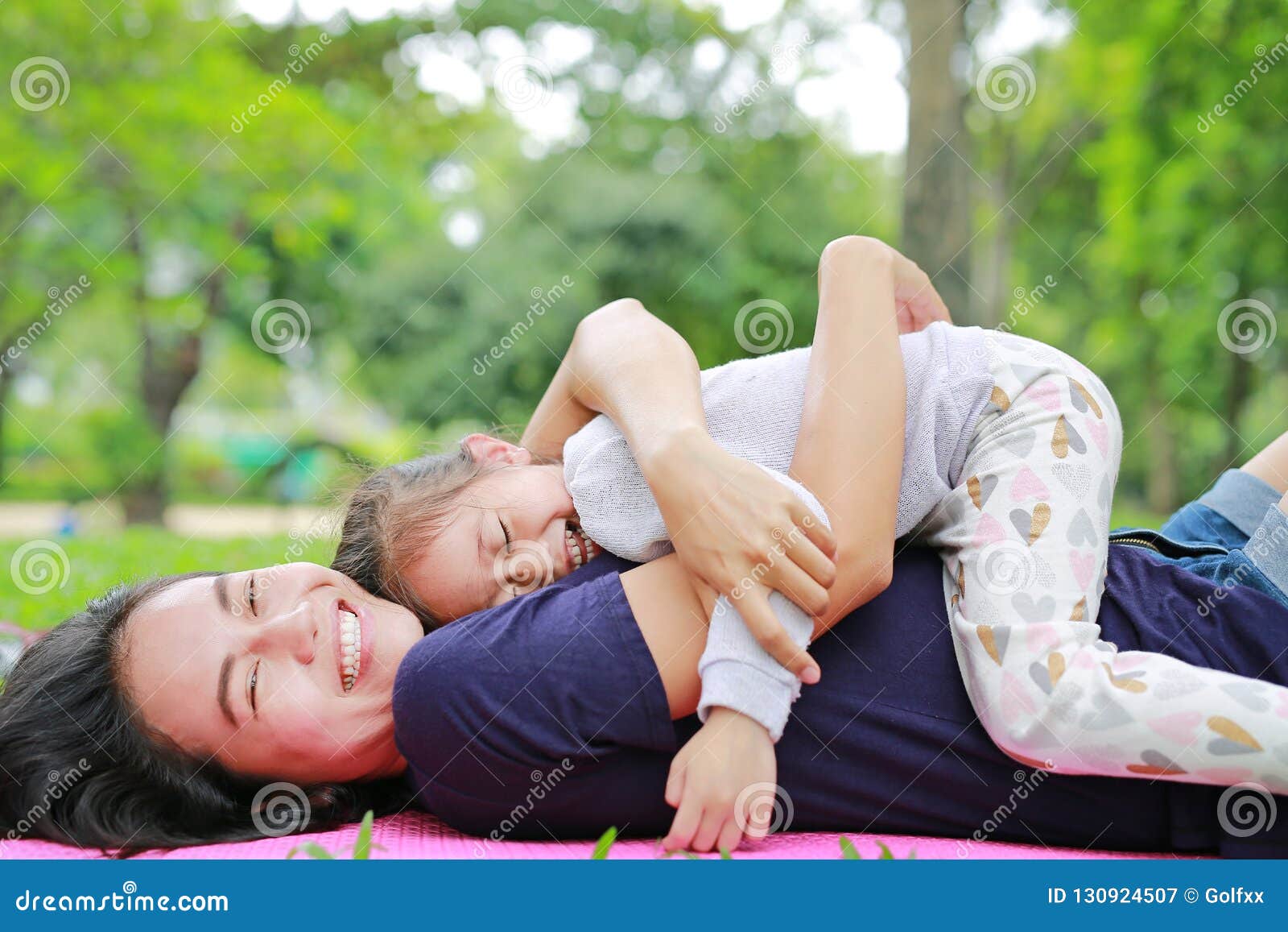 Мамаши лежа. Мама и дочка обнимаются лежа. Фото мамы с дочкой лежа. Мать обнимает дочь 10 лет в парке.