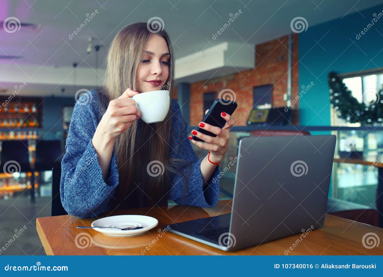 Подруга сидит в телефоне. Девушка в кафе с телефоном. Девушка со смартфоном в офисе. Девушка с телефоном в руках в кафе. Сидит за столом с телефоном.