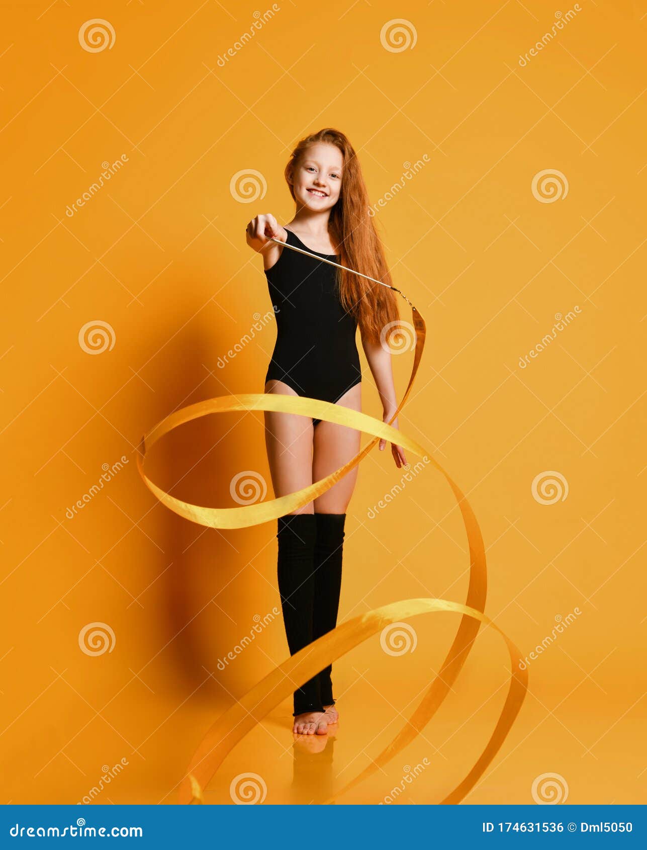 Тонкий Redhaired гимнастка девушки в черных купальнике и чулки делает  ритмические гимнастические упражнения с лентой, вертясь Стоковое Фото -  изображение насчитывающей поколение, волосы: 174631536