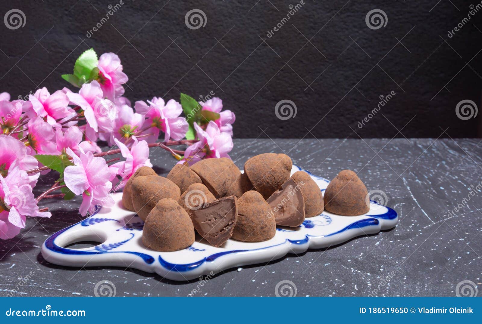 Трюфели шоколада на фоне Sprig вишневого цвета керамики на заднем плане  темной панели Стоковое Фото - изображение насчитывающей пралине, сладостно:  186519650