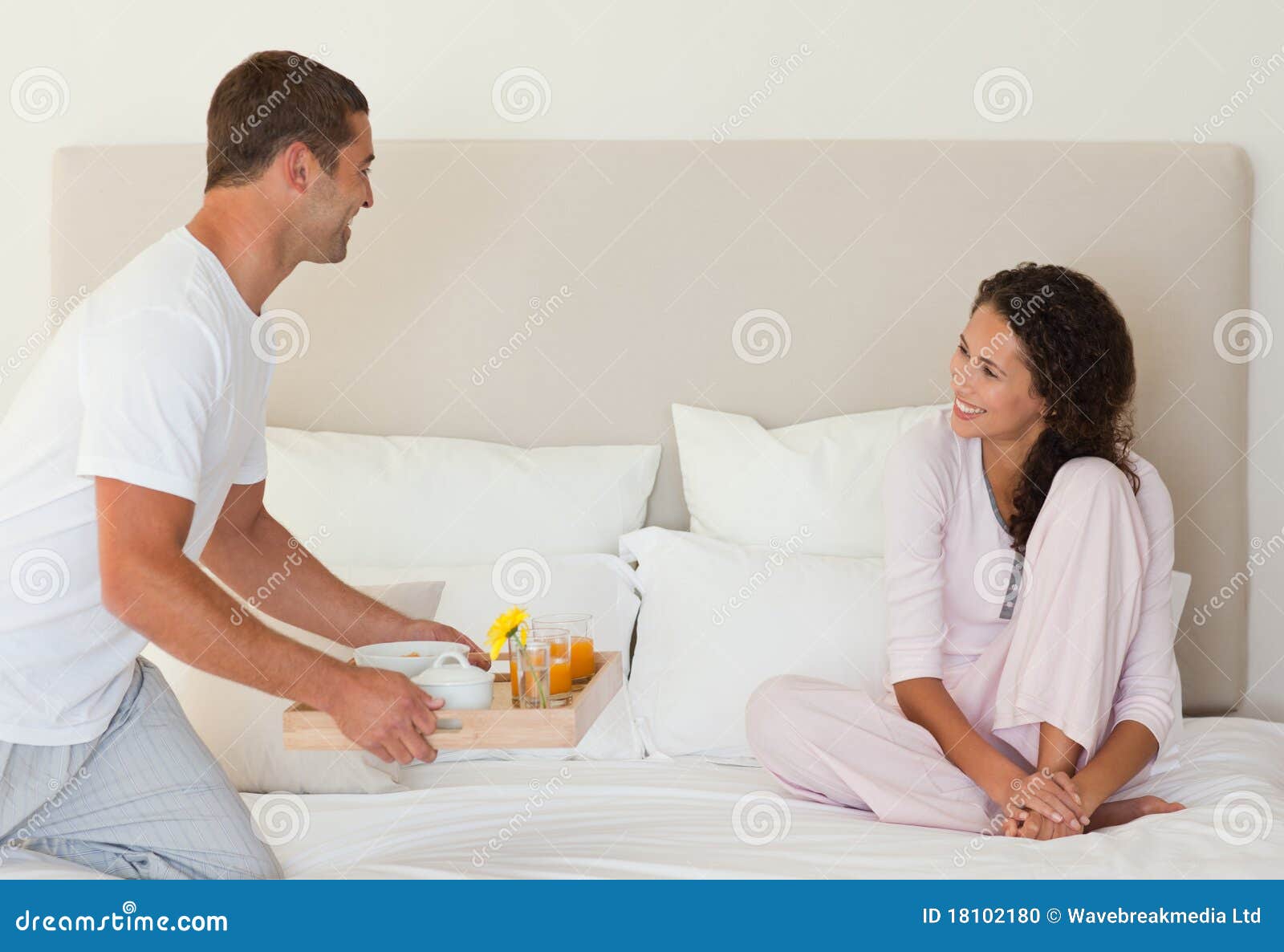 Принесла мужу видео. Мужчина приносит завтрак в постель. Муж несет в постель жену. Несущая кровати. Женщина приносит мужу в постель завтрак.