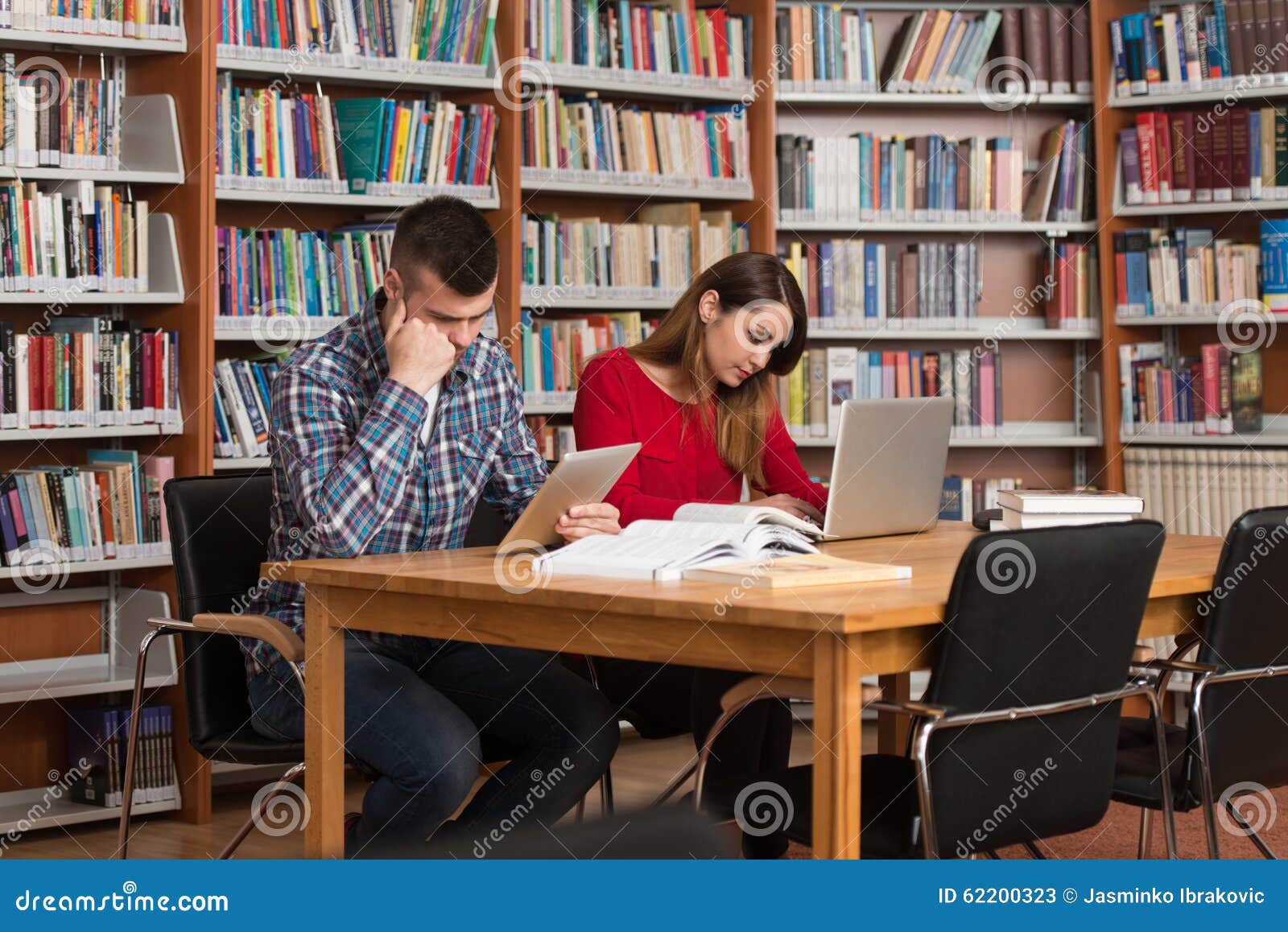 Она сидит в библиотеке. Сидит в библиотеке. Сидя в библиотеке. Студентка в библиотеке сидит. Читает в библиотеке за столом.