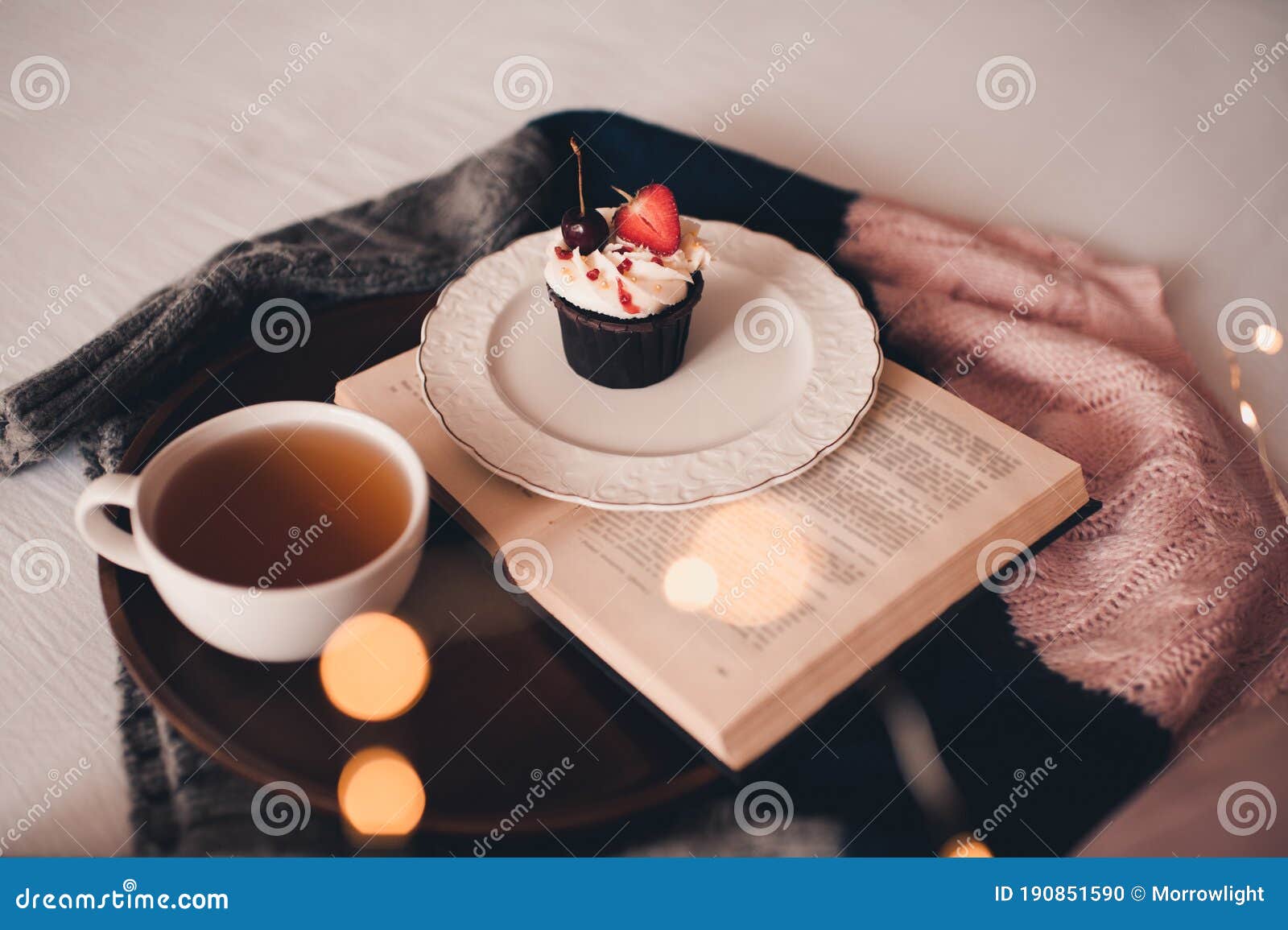 Чай с пирожными сервируется на открытой книге Стоковое Фото - изображение  насчитывающей домодельно, булочка: 190851590