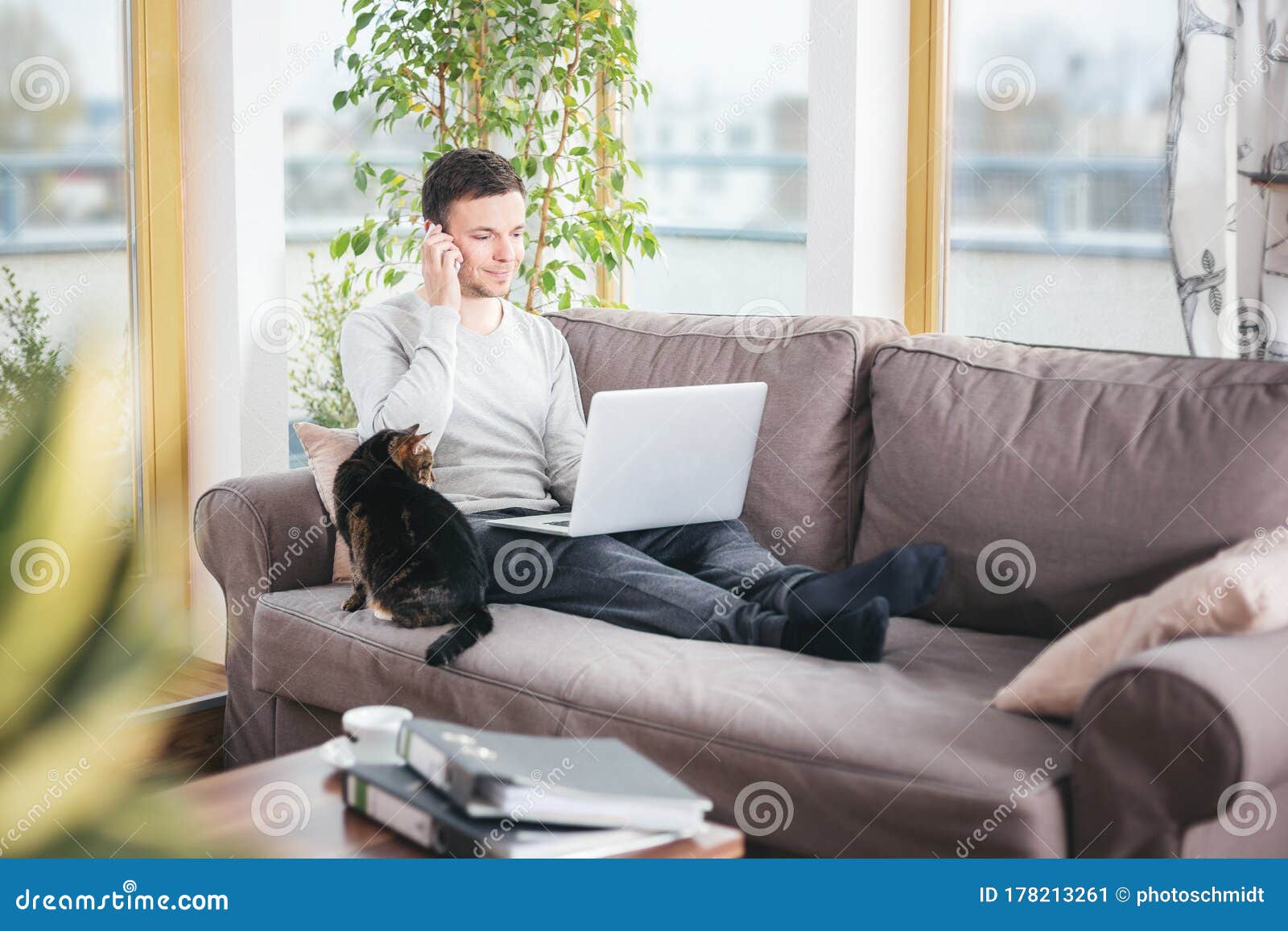 Человек дома на диване с ноутбуком Стоковое Изображение - изображениенасчитывающей соединение, вскользь: 178213261