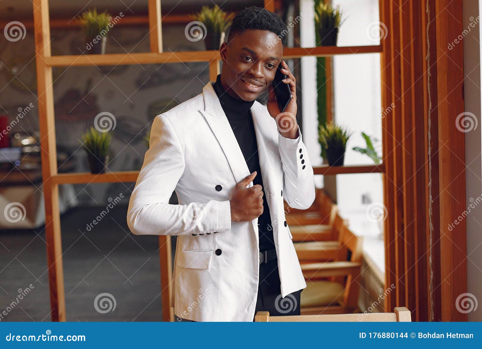 Черный человек в белом пиджаке, стоящего с телефоном Стоковое Фото -изображение насчитывающей способ, этничность: 176880144