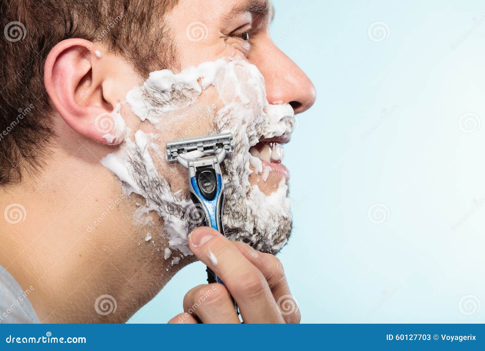 Приснилось брить. Типы бритья. Формы для бритья лица. Мужчина бреется на черном фоне. Мужчина бреется электробритвой.