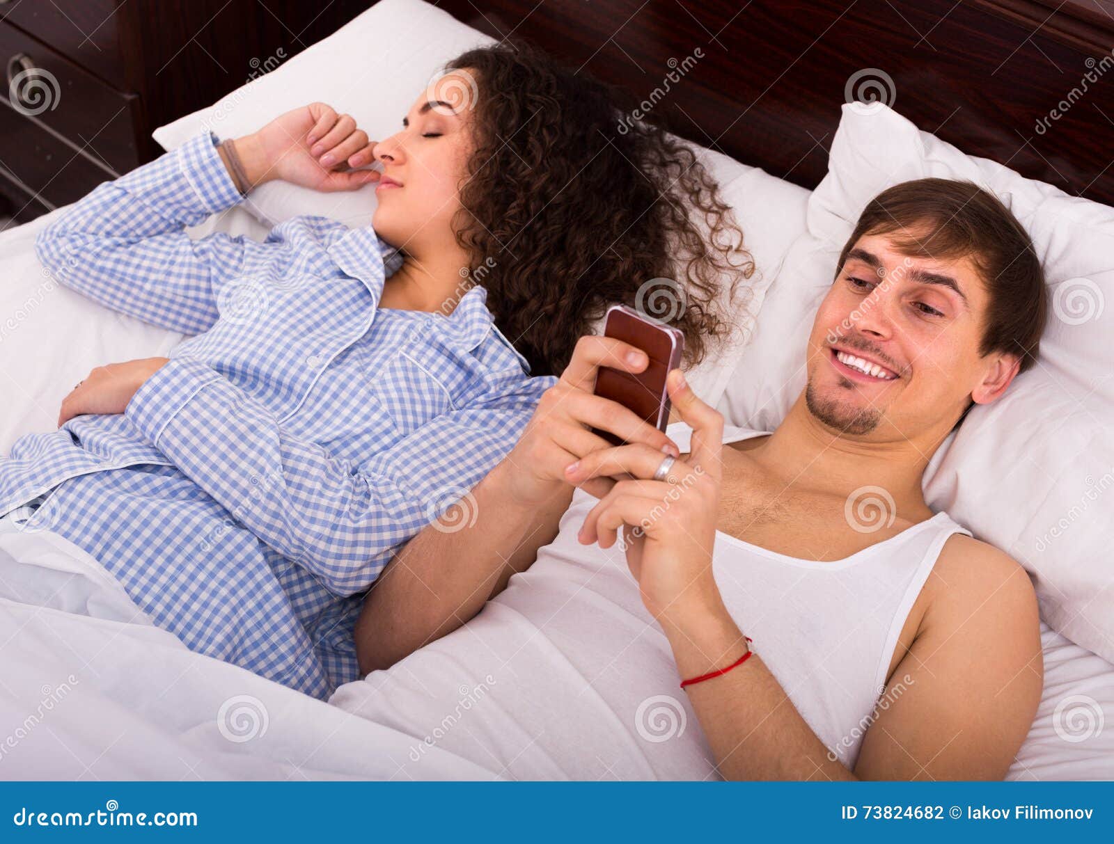 Жена укладывает мужу спать. Couple texting in Bed оригинал. Спала мужа.