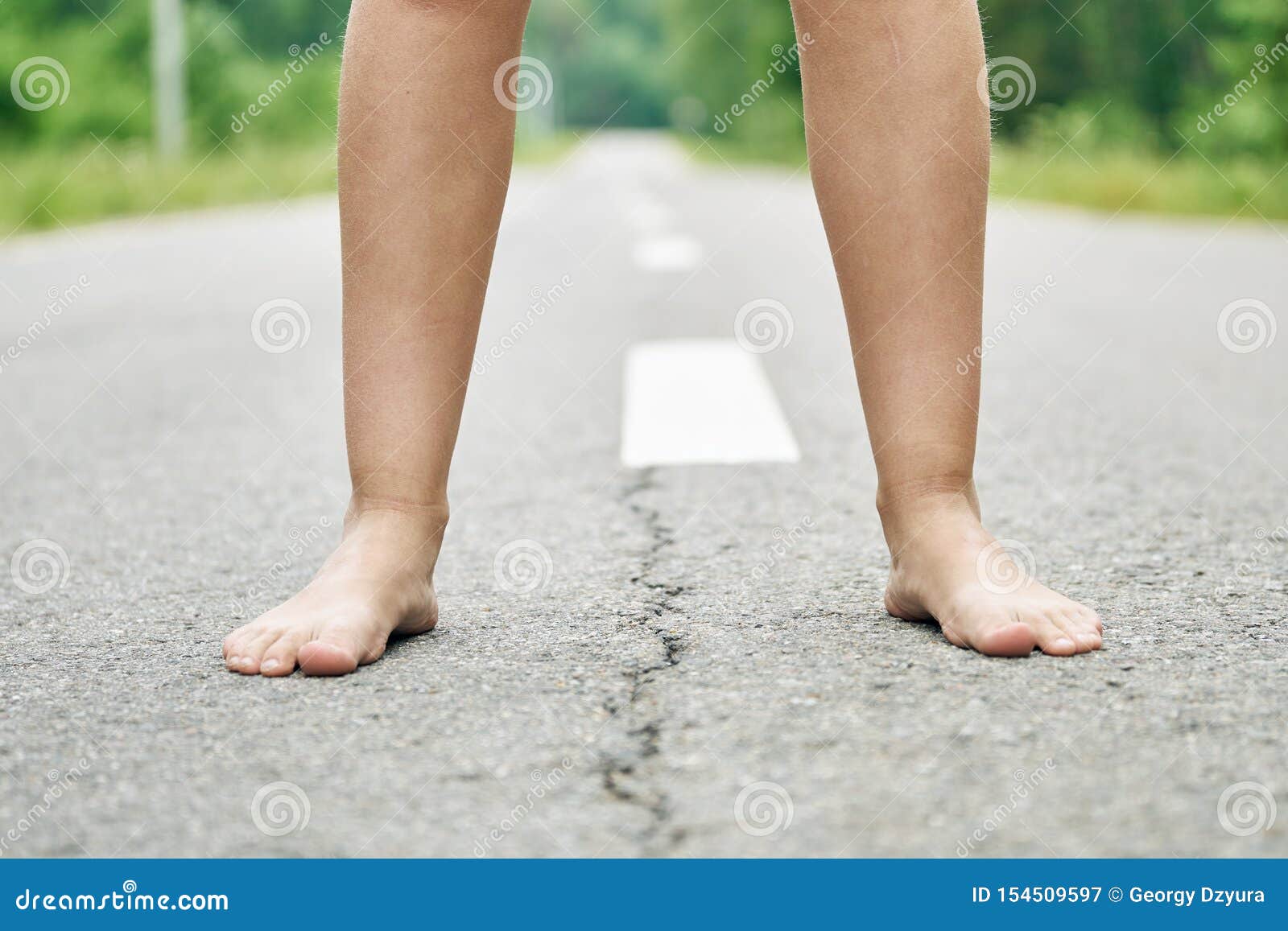 一个少女立场的赤脚在柏油路关闭的库存图片 图片包括有