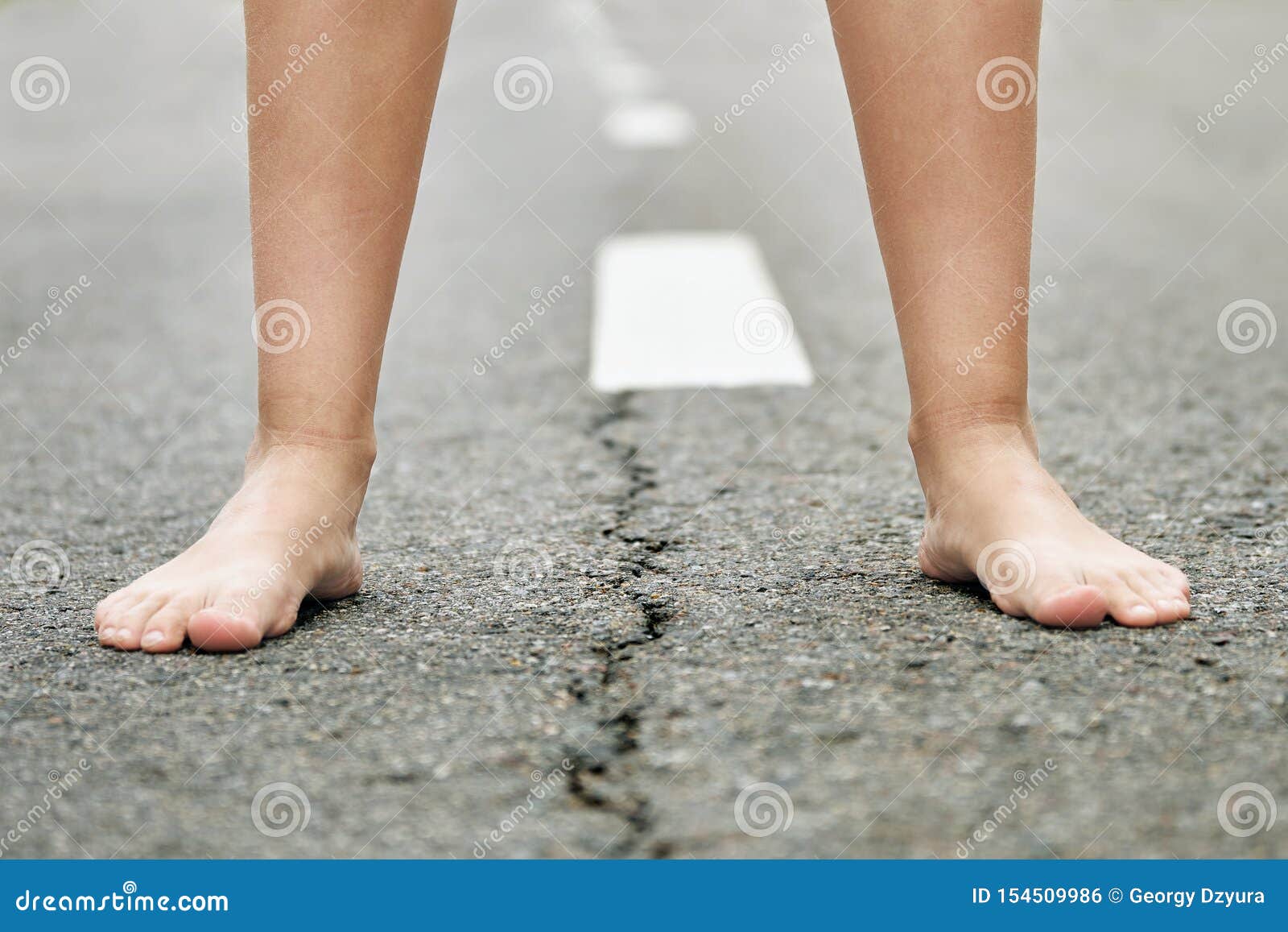 一个少女立场的赤脚在柏油路关闭的库存照片 图片包括有