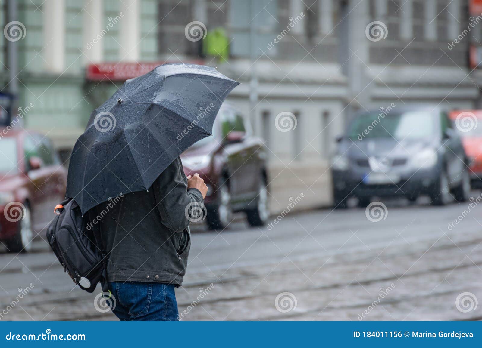 一个男人在雨伞下沿着道路和电车轨道走库存照片 图片包括有跟踪 男人 方式 全能 天气 室外