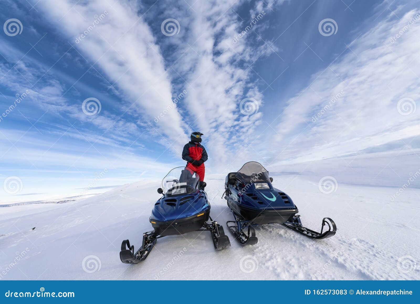 两辆雪地摩托车排成一列 左边有一个男孩他穿成在寒冷的山里开车库存图片 图片包括有放松 横向