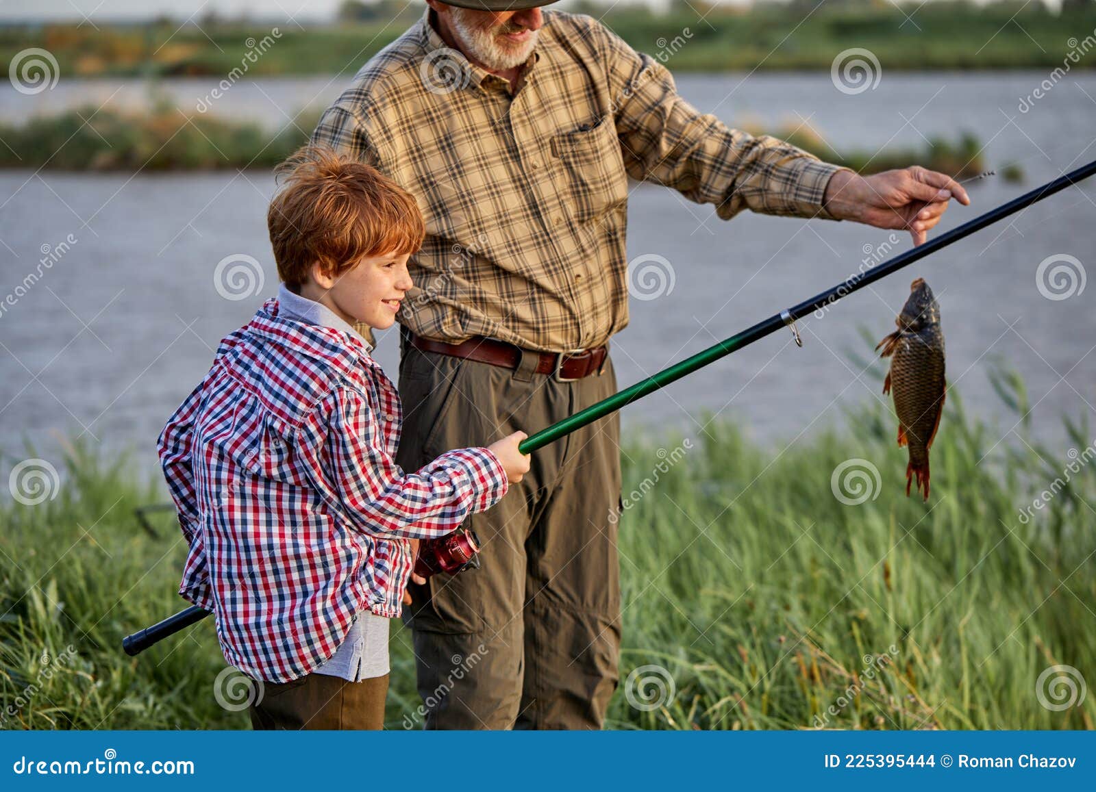和祖父在湖里钓鱼的小孩. 钓着鱼竿的鱼既开心又兴奋库存照片. 图片包括有成熟, 渔夫, 成人, 中间- 225395444