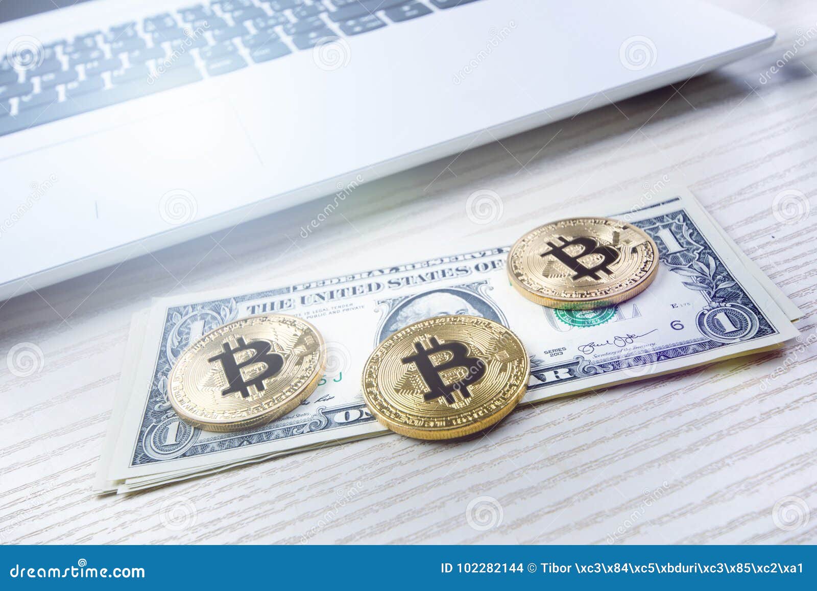 在一张桌上的bitcoin金黄硬币与美元钞票和膝上型计算机虚拟的货币cryptocurrency事务办公室背景库存照片 图片包括有硬币 新建
