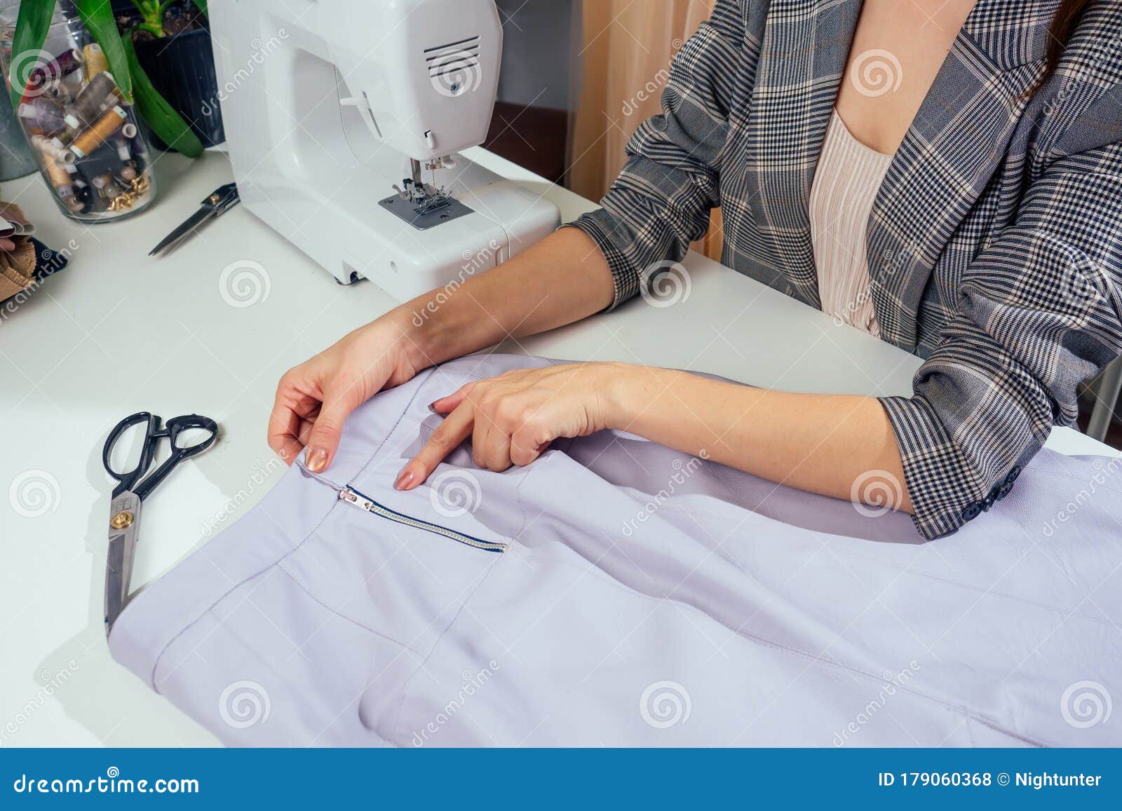 在她的缝纫工作室里 一件方格夹克里缝着的缝纫女工的画像 她在衣服衬里里展示库存照片 图片包括有女装裁制业 布料 在她的缝纫工作室里 一件方格夹克里缝着的缝纫女工的画像 她在衣服衬里里展示库存照片 图片包括有女装裁制业 布料