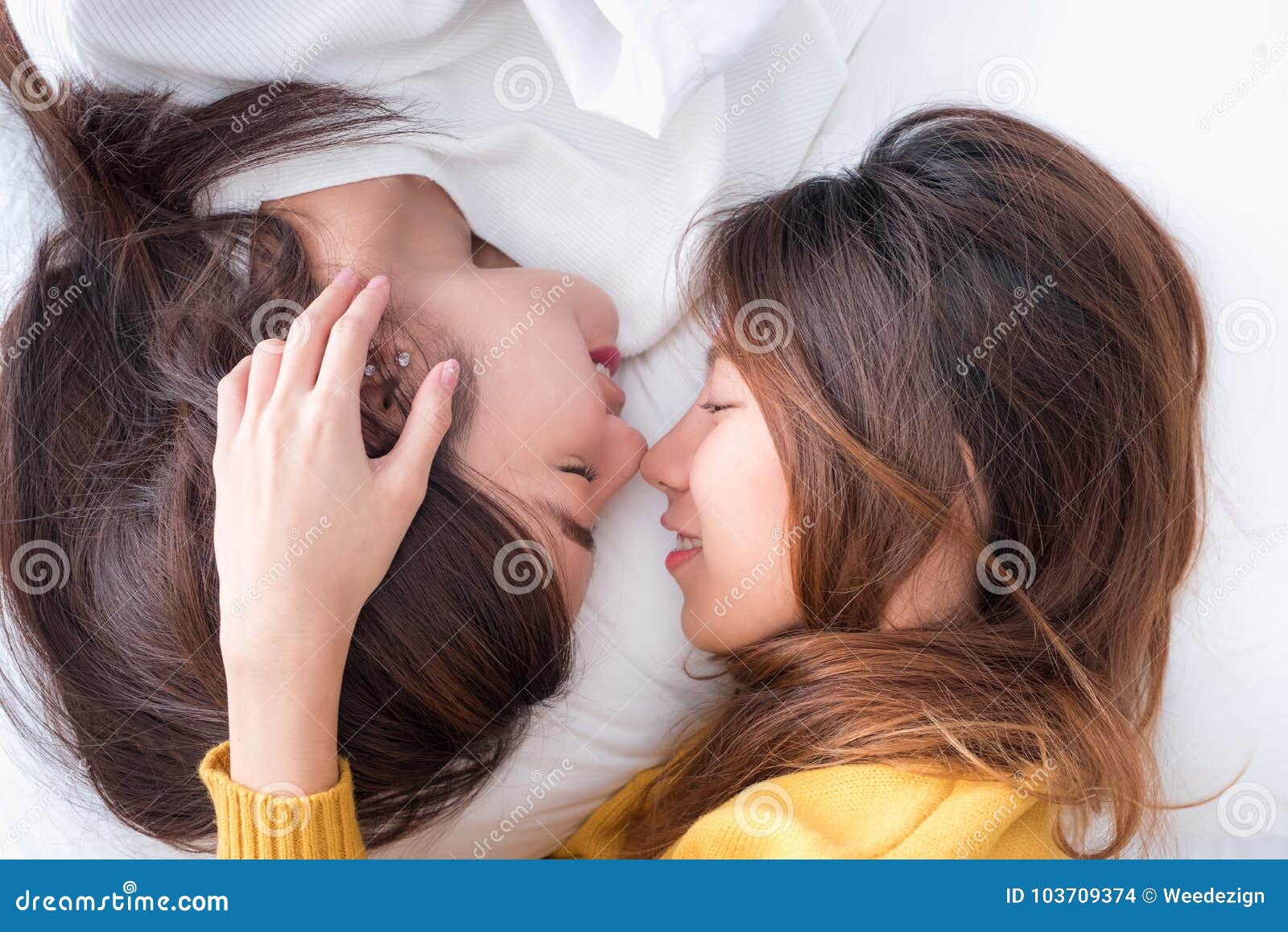 在床和鼻子亲吻的亚洲女同性恋的LGBT夫妇位置充满幸福库存照片- 图片  image